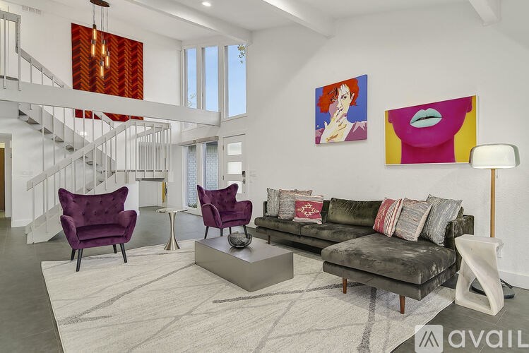 A living room with a purple chair and a grey couch.