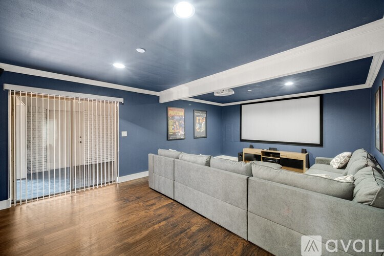 A living room with a grey couch and a wooden floor.