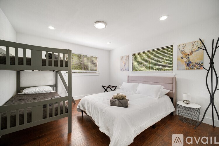 A bedroom with a white bed and a bunk bed.