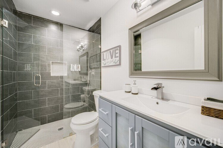 A bathroom with a white toilet and a grey cabinet.