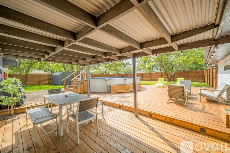 A wooden deck with a table and chairs under a roof.