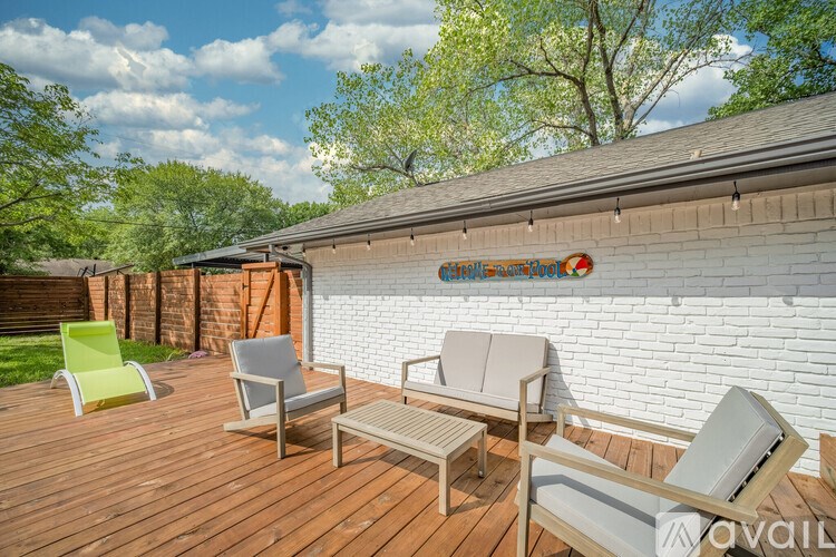 A wooden deck with two chairs and a bench.