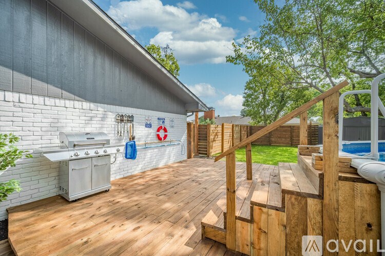 A wooden deck with a staircase leading to a pool area.