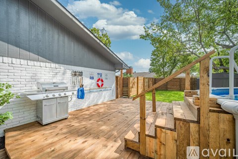 A wooden deck with a staircase leading to a pool area.
