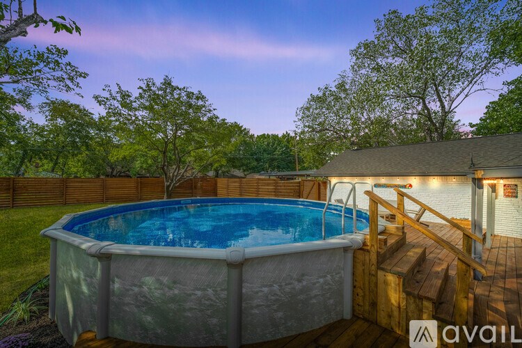 A backyard with a pool and deck.