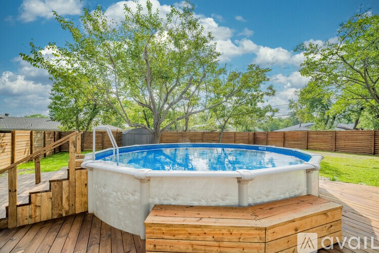 A hot tub sits on a wooden deck surrounded by trees.