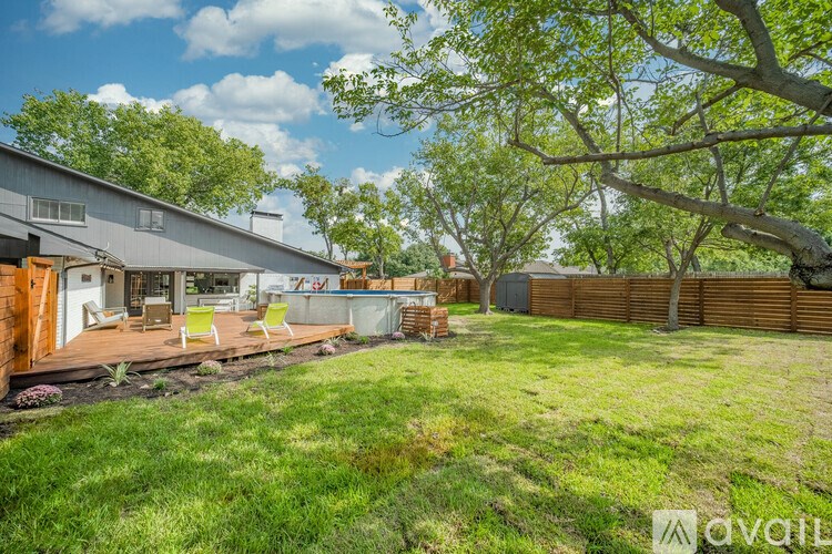 A backyard with a deck and a tree.