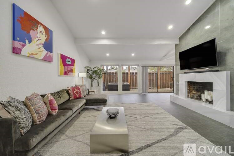 A modern living room with a grey sofa and a fireplace.