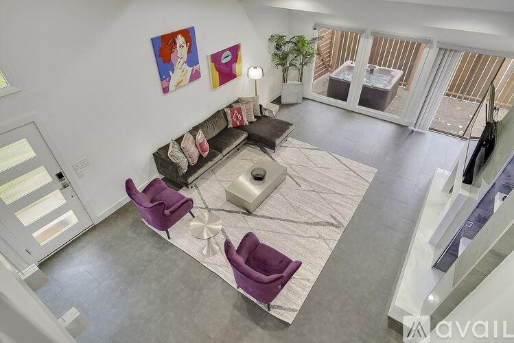 A living room with a couch, chairs, and a rug.
