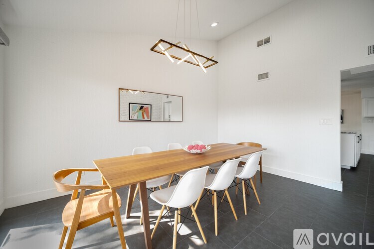 A modern dining room with a wooden table and chairs.