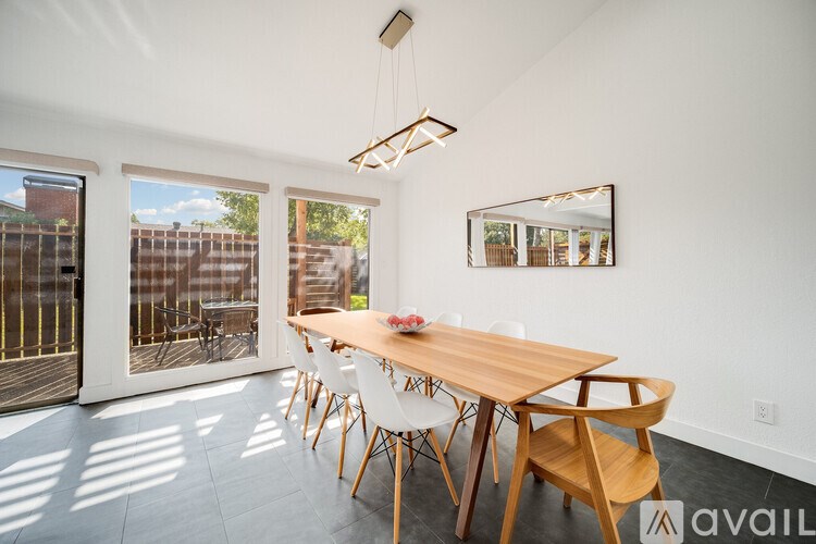 A dining room with a wooden table and chairs.