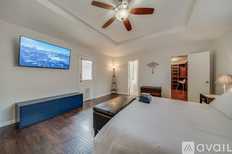 A bedroom with a large bed and a flat screen TV mounted on the wall.