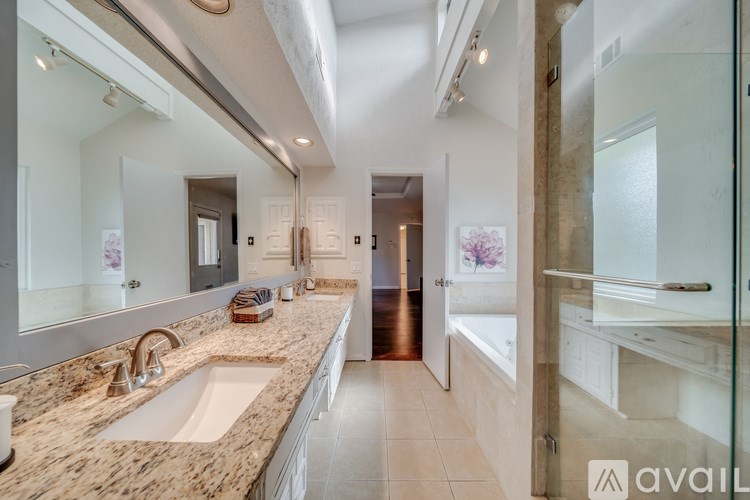 A bathroom with a marble countertop and a large mirror.