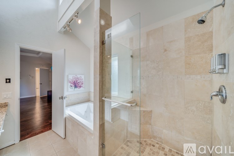 A bathroom with a glass shower door and a bathtub.