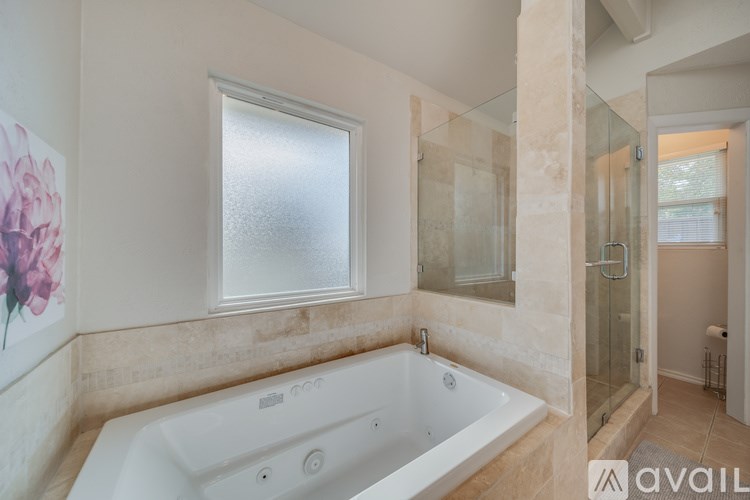 A bathroom with a tub and a window.