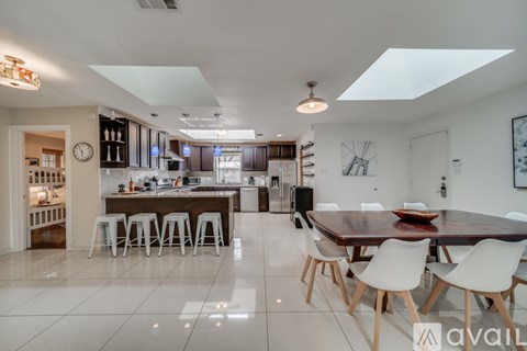 A modern kitchen with a dining table and chairs.