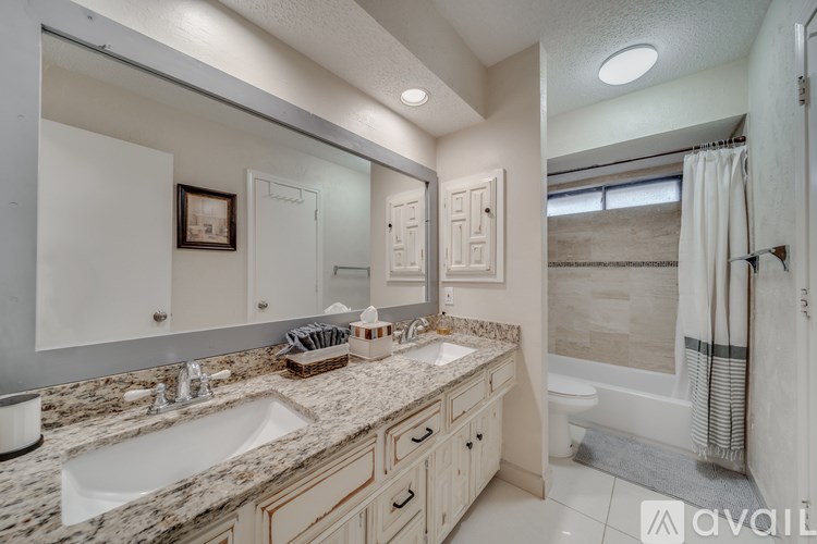 A bathroom with a marble countertop and a large mirror.
