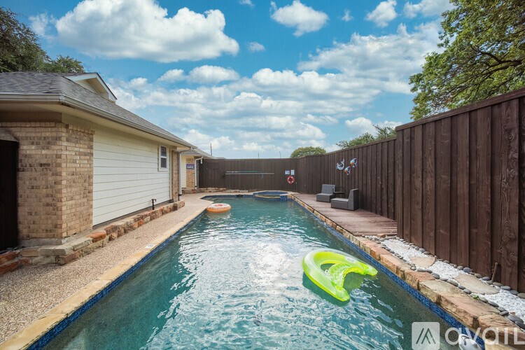 A small inflatable kayak is floating in a residential pool.
