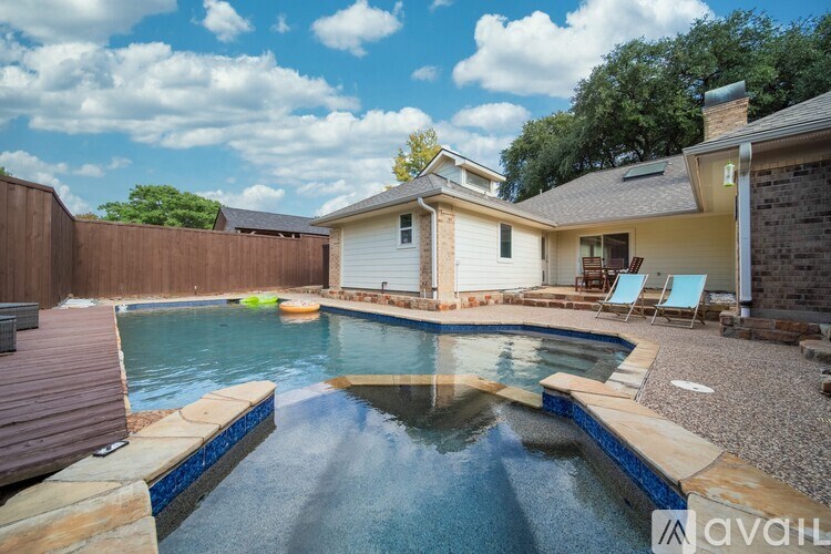 A backyard with a pool and a house.