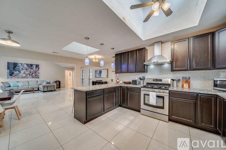 A modern kitchen with dark wood cabinets and a white countertop.