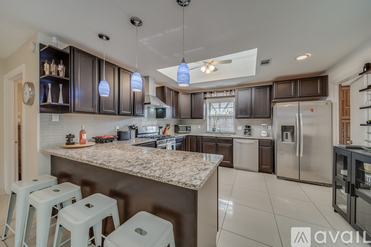 A kitchen with a marble countertop and stainless steel appliances.