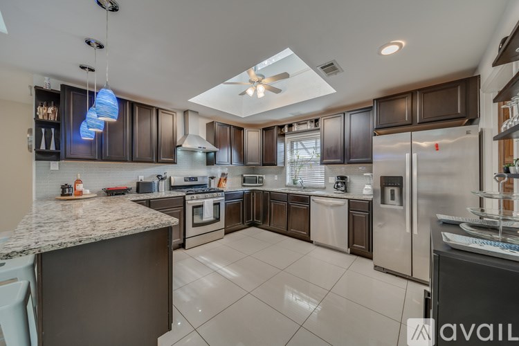 A modern kitchen with dark brown cabinets and stainless steel appliances.