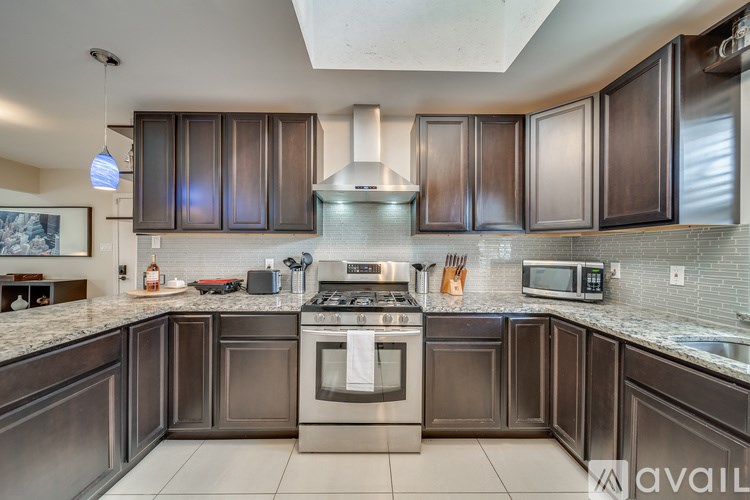 A kitchen with dark brown cabinets and stainless steel appliances.