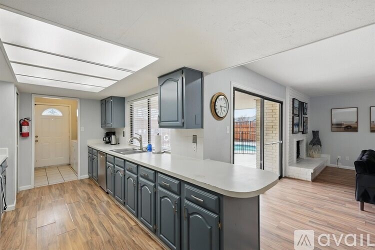 A kitchen with a white countertop and wooden floors.
