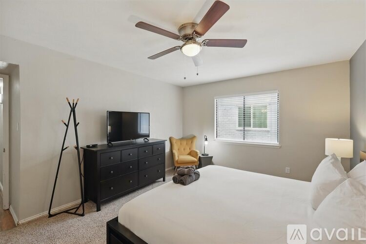 A bedroom with a bed, dresser, and television.