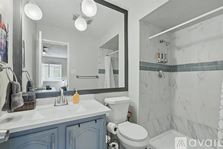 A bathroom with a white toilet and a mirror above the sink.