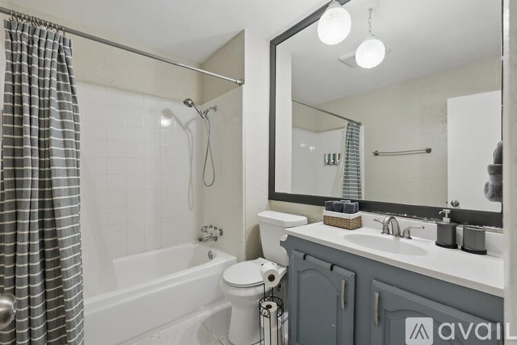 A bathroom with a white tub, sink, and toilet.