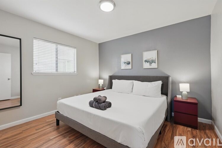 A bedroom with a large bed and a mirror on the wall.