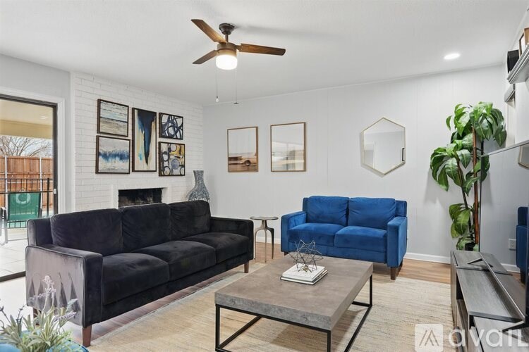 A living room with a black couch, blue chair, and a coffee table.