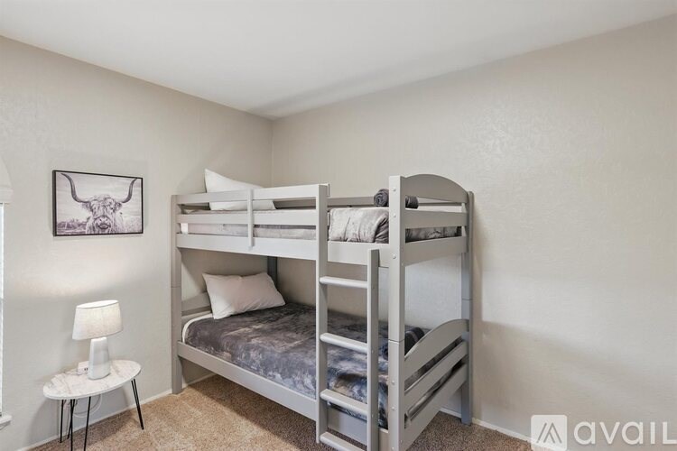 A bedroom with a bunk bed and a small table.