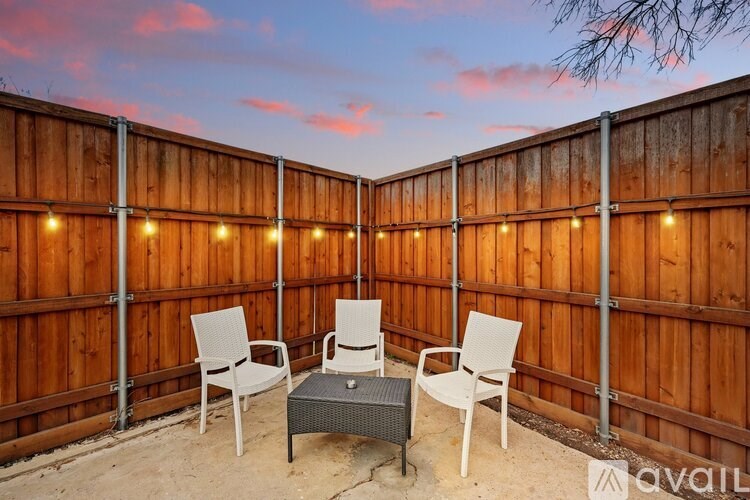 A patio with a table and chairs is set up on a wooden deck.