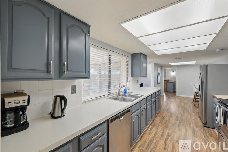 A kitchen with dark cabinets and a white countertop.
