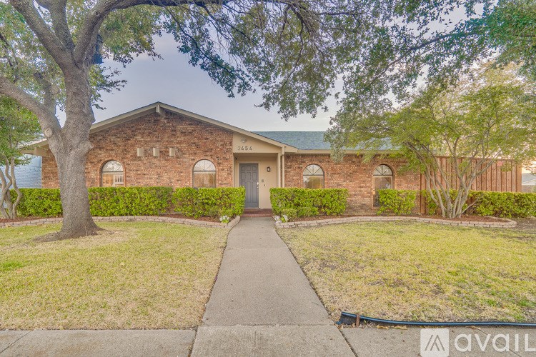 A house with a brick facade and a green lawn.