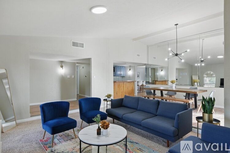 A living room with a blue sofa, two chairs, and a coffee table.