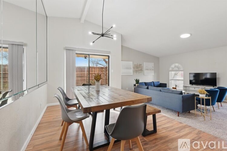 A modern dining room with a wooden table and chairs.