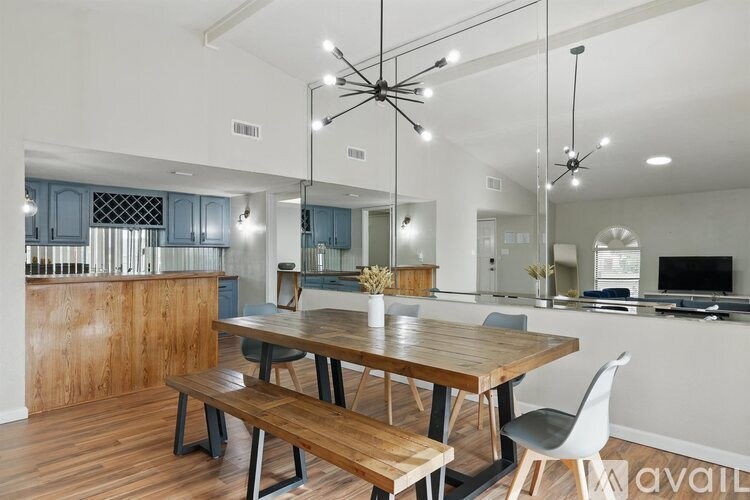 A modern kitchen with a wooden table and bench seating.