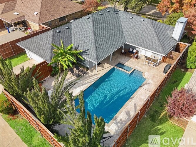 A backyard with a pool and a patio area.