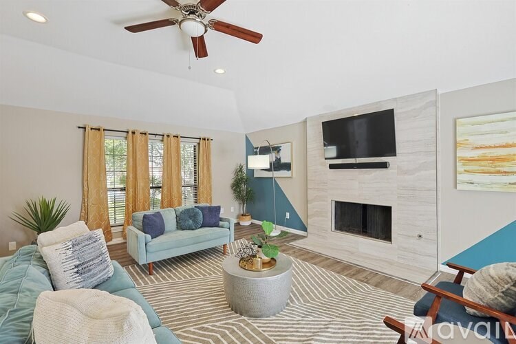 A living room with a blue couch, a fireplace, and a television.