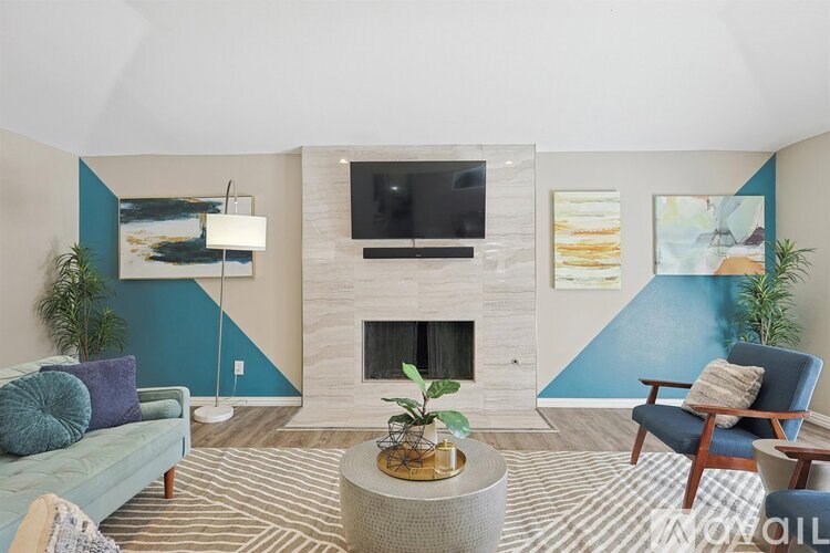 A living room with a fireplace and a TV mounted on the wall.