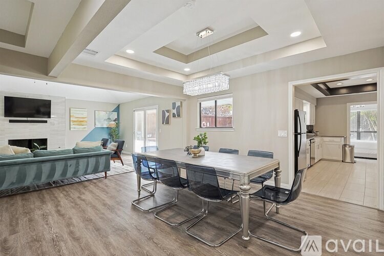 A modern dining room with a glass table and chairs.