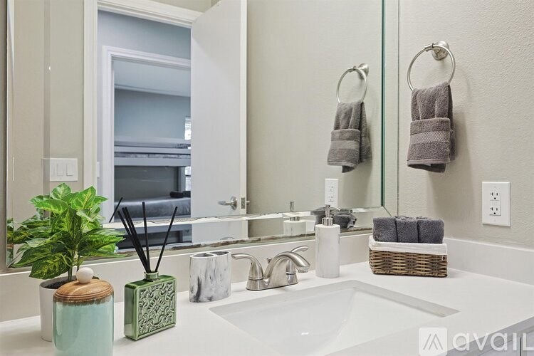 A bathroom with a white sink and a mirror.