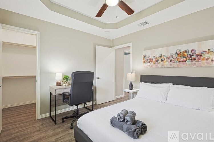 A bedroom with a bed, desk, and chair.