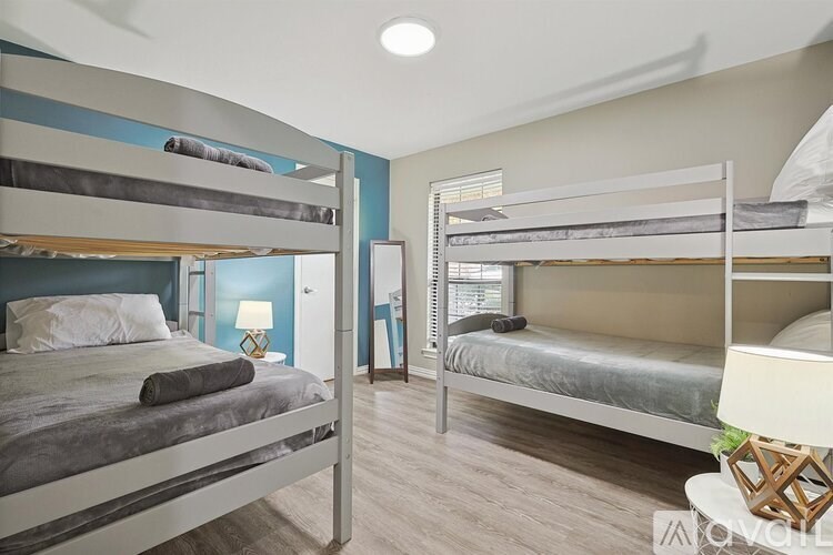 A bedroom with two bunk beds and a single bed.