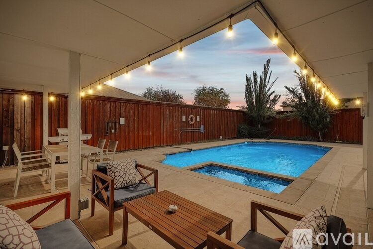 A pool area with a wooden table and chairs.