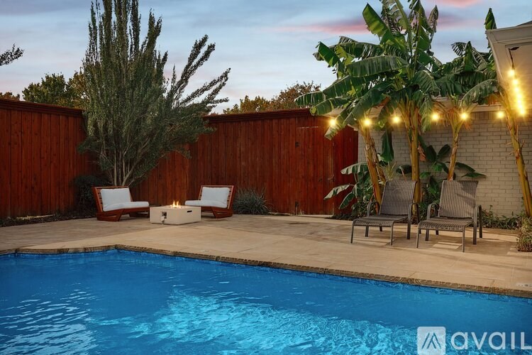 A pool surrounded by a wooden fence and a tree.