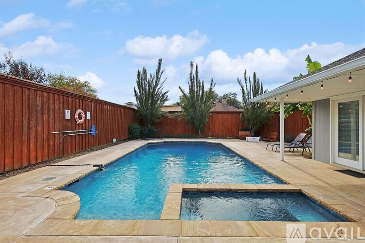 A pool surrounded by wooden fence and trees.
